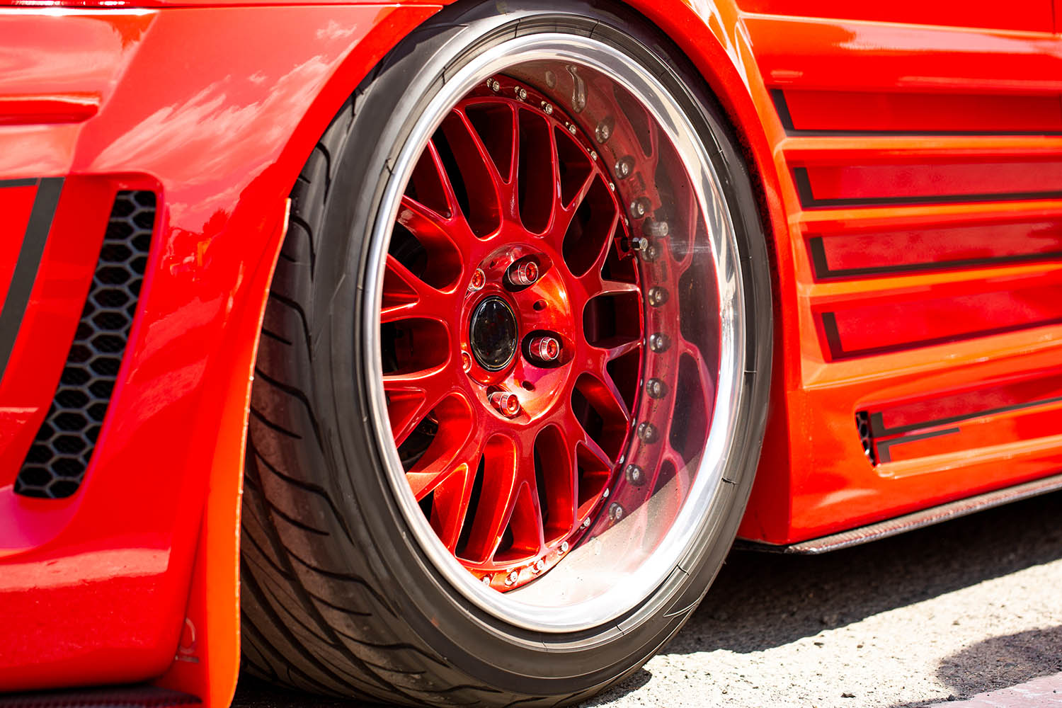 Red sports tuned car rear view of the wheel, close-up . Fashion car day on the road